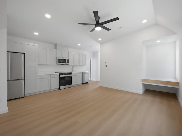 kitchen featuring stainless steel appliances, light wood-style floors, a sink, and ceiling fan