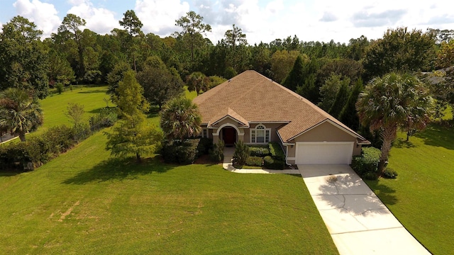 view of front of house with a front yard, concrete driveway, a garage, and stucco siding