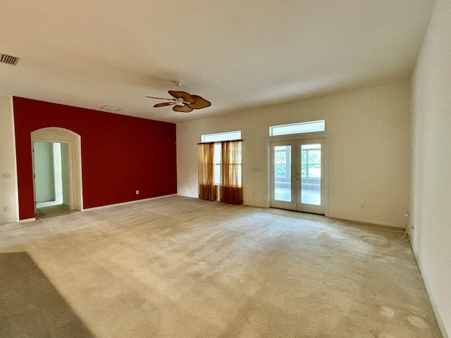 carpeted spare room featuring french doors and ceiling fan