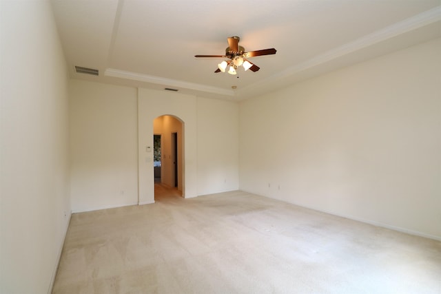 carpeted empty room with a raised ceiling and ceiling fan