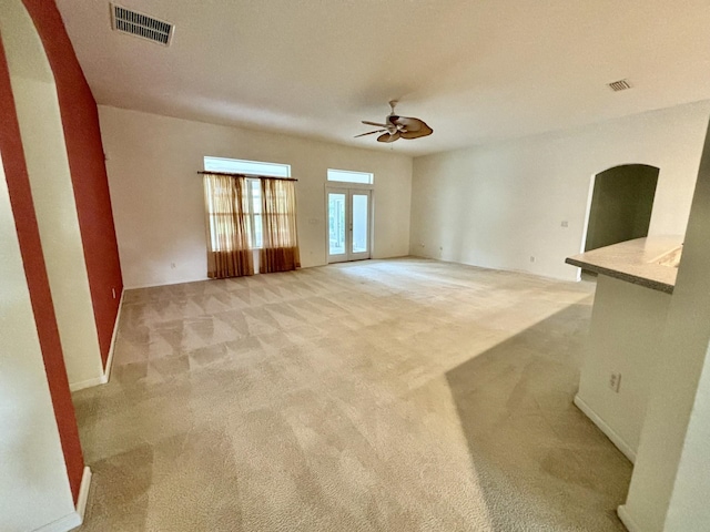 unfurnished living room with light carpet and ceiling fan