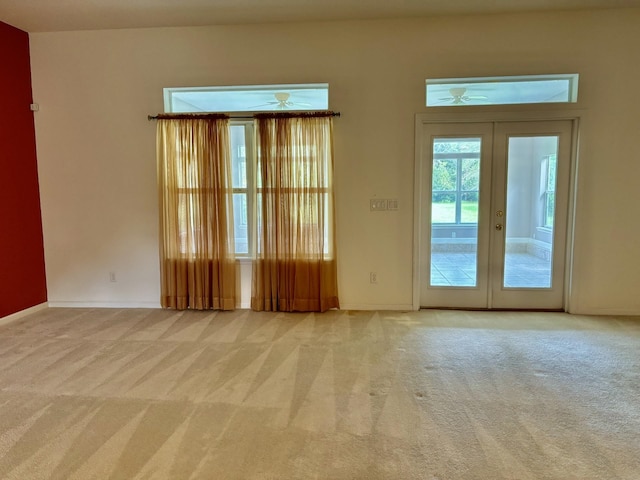 carpeted empty room with ceiling fan and french doors