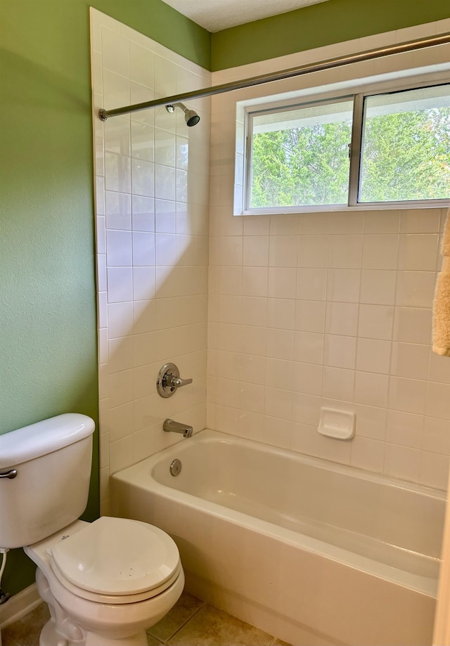 bathroom with tiled shower / bath combo and toilet