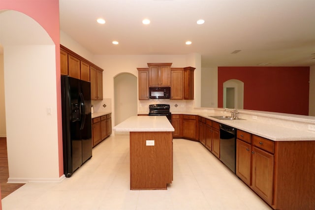 kitchen featuring a center island, black appliances, sink, tasteful backsplash, and kitchen peninsula