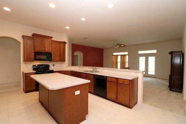 kitchen featuring ceiling fan, sink, kitchen peninsula, a kitchen island, and black appliances