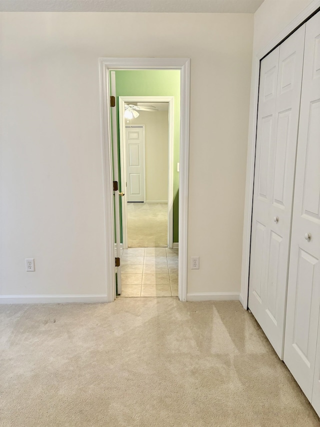 unfurnished bedroom with light colored carpet and a closet