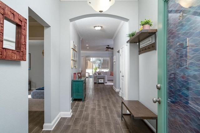 hall with a textured ceiling, dark hardwood / wood-style flooring, and ornamental molding