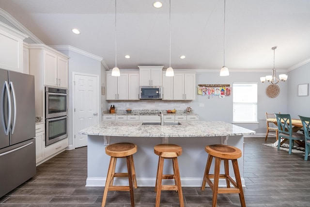 kitchen featuring stainless steel appliances, a breakfast bar, backsplash, and white cabinetry