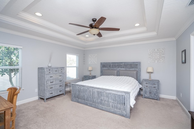 bedroom with a tray ceiling, ceiling fan, light colored carpet, and ornamental molding