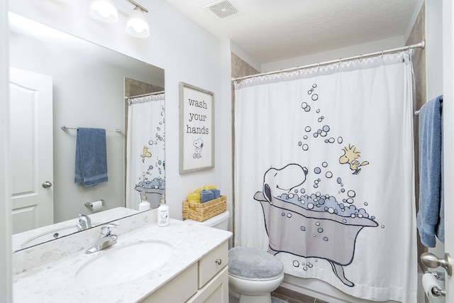 bathroom featuring walk in shower, vanity, a textured ceiling, and toilet