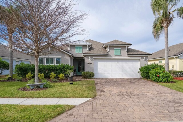 view of front of property featuring a front yard and a garage