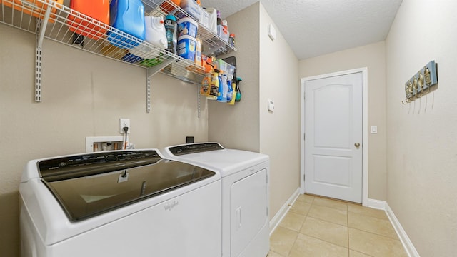 clothes washing area with light tile patterned floors, a textured ceiling, and independent washer and dryer