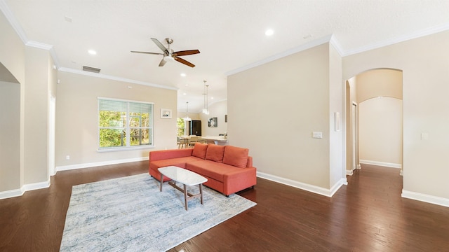 living room with ornamental molding, dark hardwood / wood-style floors, and ceiling fan