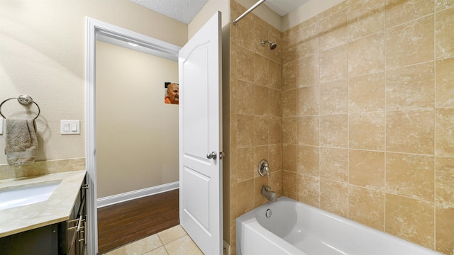 bathroom with tiled shower / bath, vanity, tile patterned flooring, and a textured ceiling