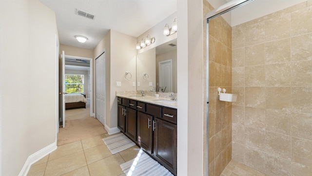 bathroom featuring vanity, tile patterned floors, and tiled shower