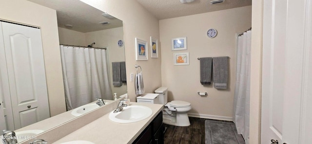 bathroom with hardwood / wood-style floors, vanity, a textured ceiling, and toilet