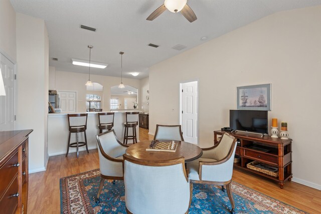 dining space with visible vents, light wood-style floors, and ceiling fan
