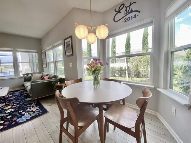 268 Sierras Loop, Saint Augustine, FL 32086 - dining room featuring healthy amount of natural light, lofted ceiling, baseboards, and light wood finished floors