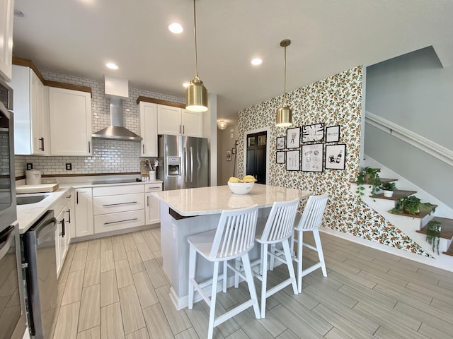 268 Sierras Loop, Saint Augustine, FL 32086 - kitchen featuring stainless steel appliances, wall chimney exhaust hood, white cabinetry, a kitchen island, and decorative backsplash