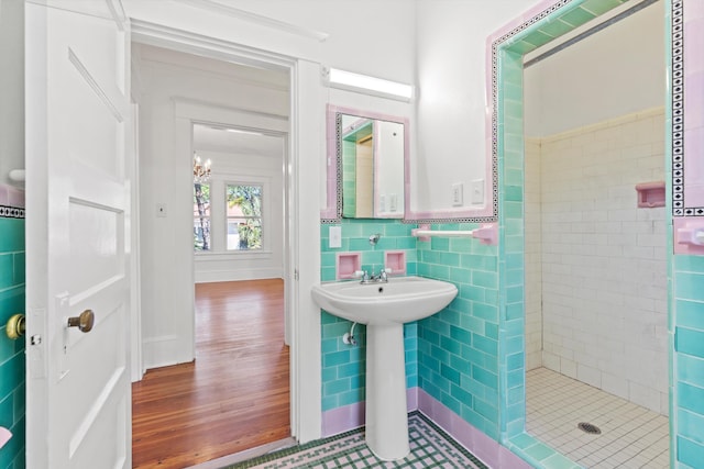 121 Washington St, Saint Augustine, FL 32084 - full bath with a wainscoted wall, a stall shower, an inviting chandelier, wood finished floors, and tile walls
