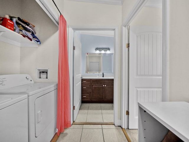 washroom featuring washing machine and clothes dryer, crown molding, sink, and light tile patterned floors