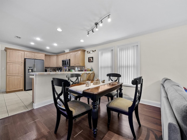 dining room with light hardwood / wood-style floors and crown molding