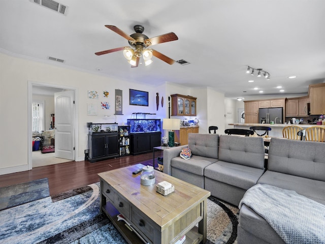 living room featuring dark hardwood / wood-style floors, ceiling fan, and ornamental molding