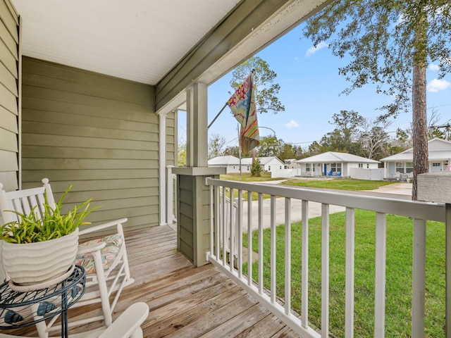 wooden deck with a lawn and a porch