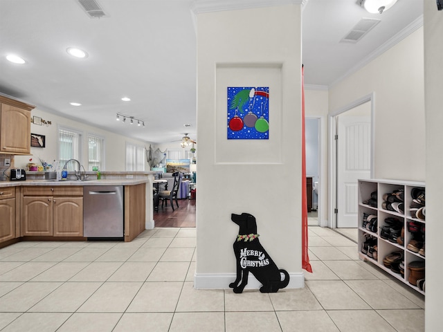 kitchen featuring sink, crown molding, stainless steel dishwasher, ceiling fan, and light tile patterned floors