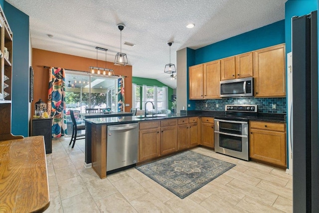 241 N Hidden Tree Dr, Saint Augustine, FL 32086 - kitchen with stainless steel appliances, tasteful backsplash, dark countertops, a textured ceiling, and hanging light fixtures
