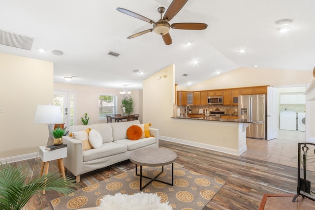 living room with lofted ceiling, washer and clothes dryer, ceiling fan, and dark hardwood / wood-style floors