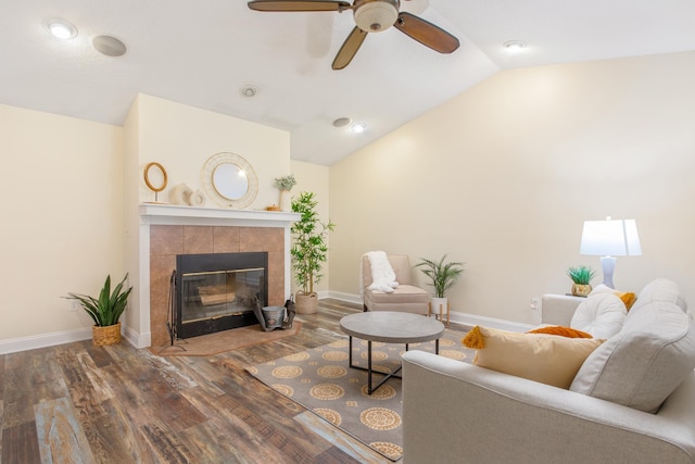 living room with a tile fireplace, hardwood / wood-style flooring, vaulted ceiling, and ceiling fan