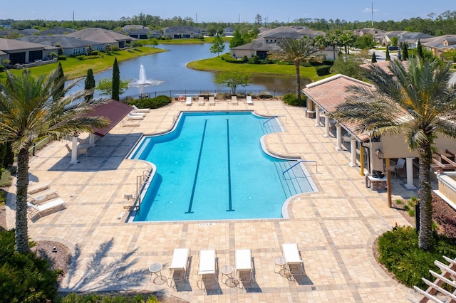 view of swimming pool featuring a patio and a water view