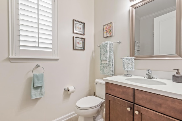 bathroom with vanity, crown molding, and toilet