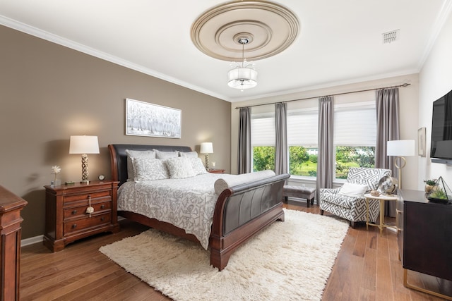 bedroom featuring ornamental molding and dark hardwood / wood-style floors