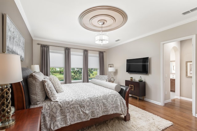 bedroom with hardwood / wood-style floors and ornamental molding