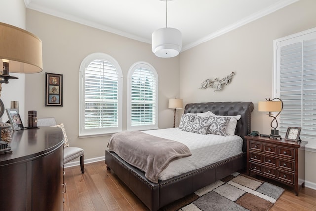 bedroom with crown molding and light hardwood / wood-style floors