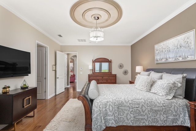 bedroom with ornamental molding and dark hardwood / wood-style flooring