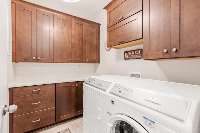 washroom featuring washing machine and dryer and cabinets