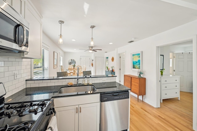 kitchen featuring sink, light hardwood / wood-style flooring, white cabinets, and appliances with stainless steel finishes