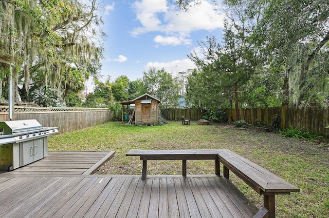 wooden deck with area for grilling, a shed, and a lawn