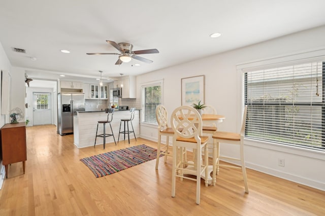 dining room with light hardwood / wood-style flooring, ceiling fan, and plenty of natural light