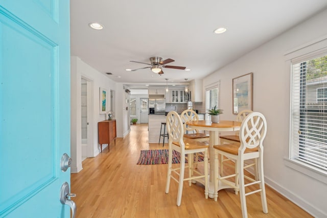 dining area with ceiling fan and light wood-type flooring