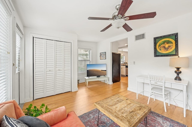 living room featuring ceiling fan and hardwood / wood-style floors