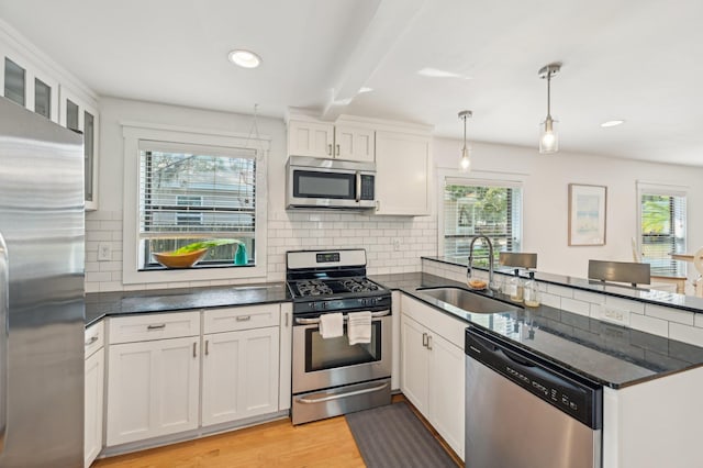 kitchen featuring sink, decorative light fixtures, white cabinets, and appliances with stainless steel finishes