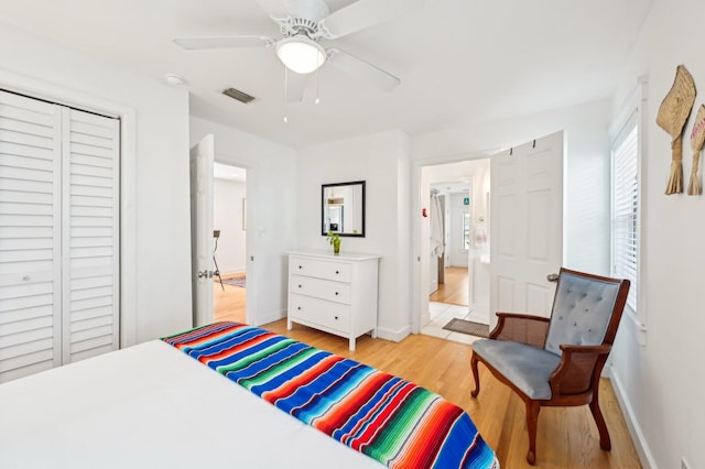 bedroom with ceiling fan, light hardwood / wood-style floors, and a closet