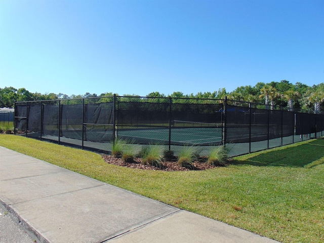 view of sport court featuring a yard and fence