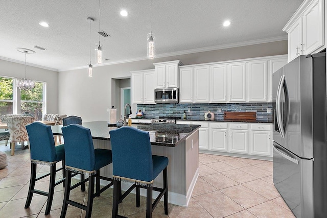 kitchen featuring light tile patterned floors, backsplash, stainless steel appliances, and crown molding