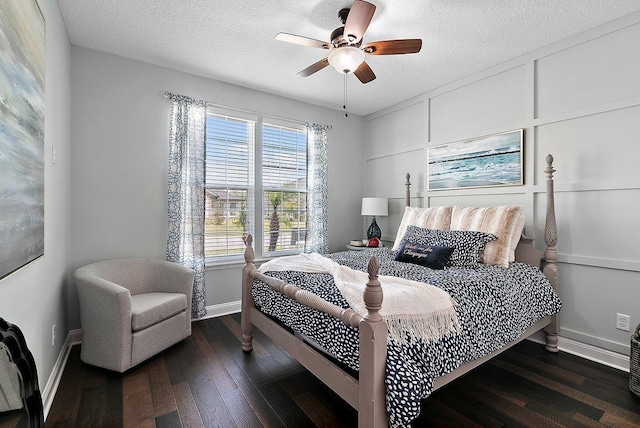 bedroom with dark wood finished floors, baseboards, and a textured ceiling