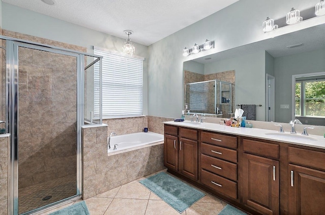 bathroom with tile patterned floors, a garden tub, a stall shower, a sink, and double vanity